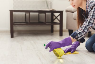 Concentrated woman polishing wooden floor