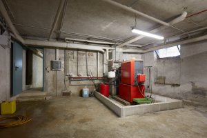 Basement with red heating boiler in old house interior