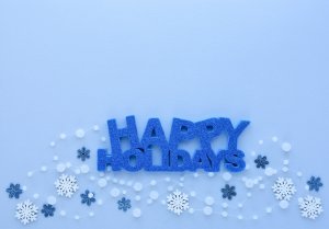 Christmas or New Year greeting card. Greeting “Happy Holidays” and snowflakes on pastel blue background. Flat lay, top view, copy space Christmas or New Year greeting card. Greeting “Happy Holidays” and snowflakes on pastel blue background. Flat lay, top view, copy space
